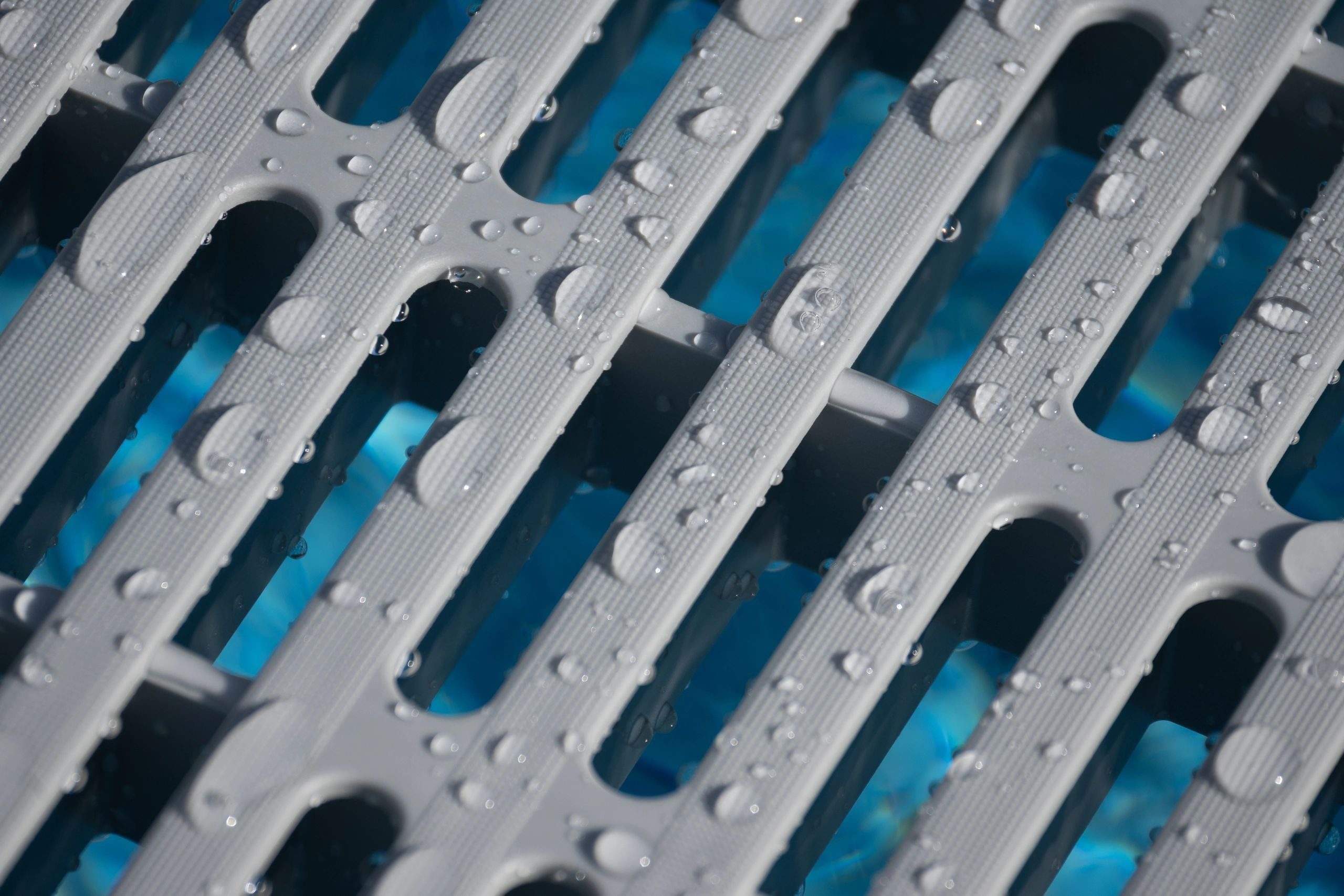 Wet metal grate with water droplets
