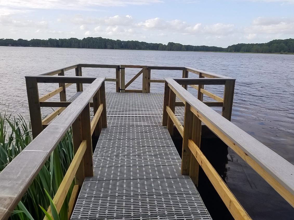 Wooden pier extending into calm lake.