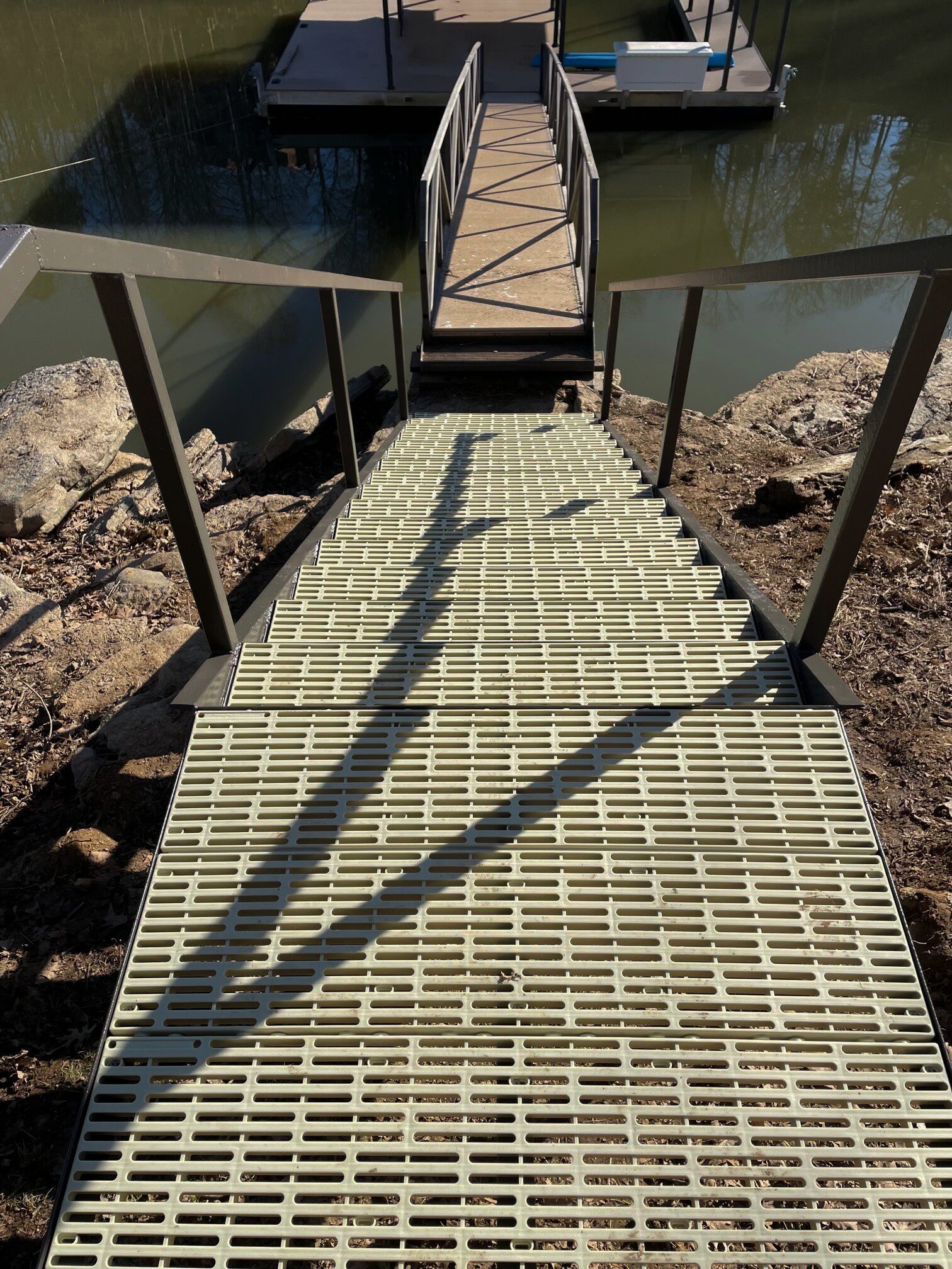 Metal stairs leading to a lake dock.