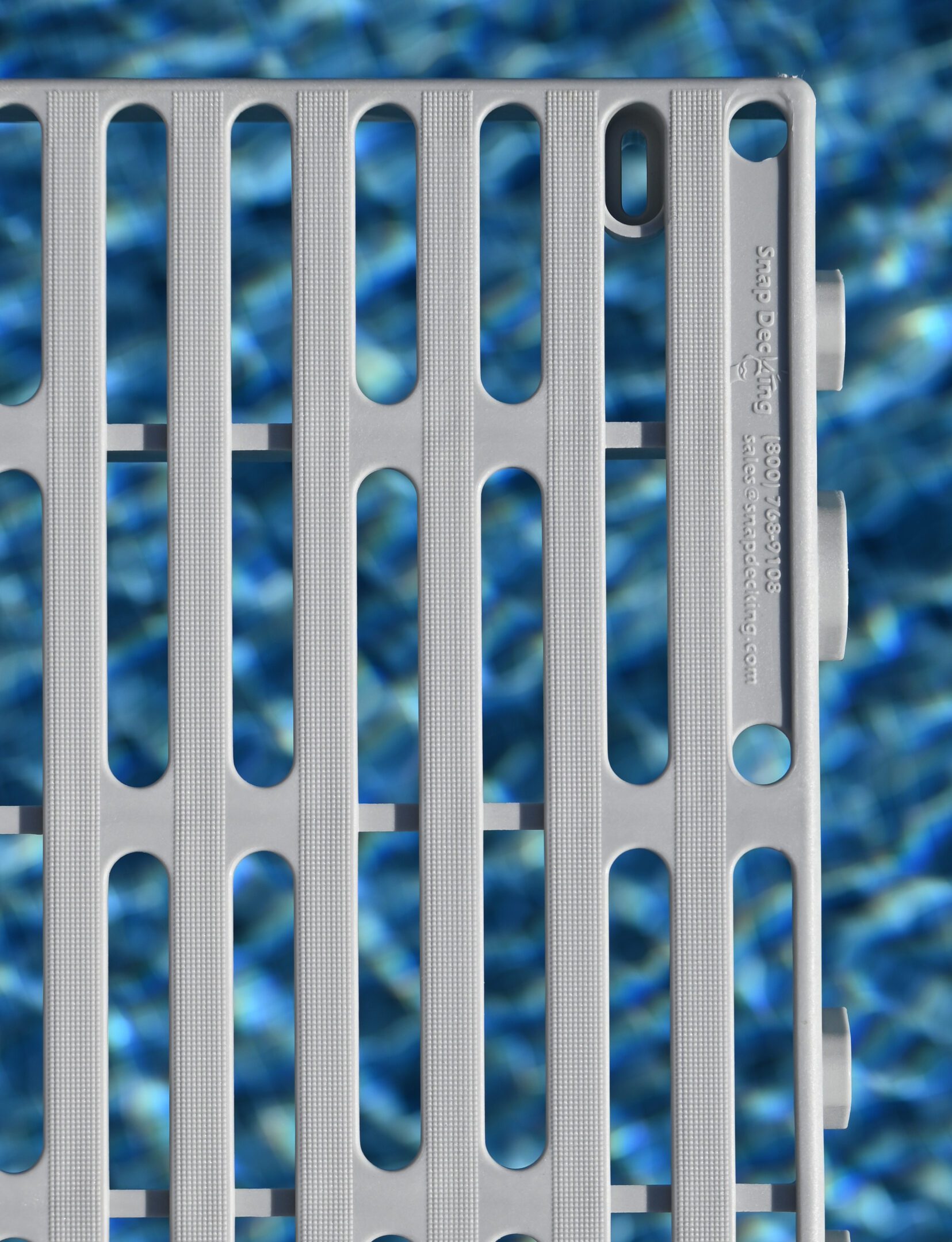 Gray plastic grid over rippling water background.
