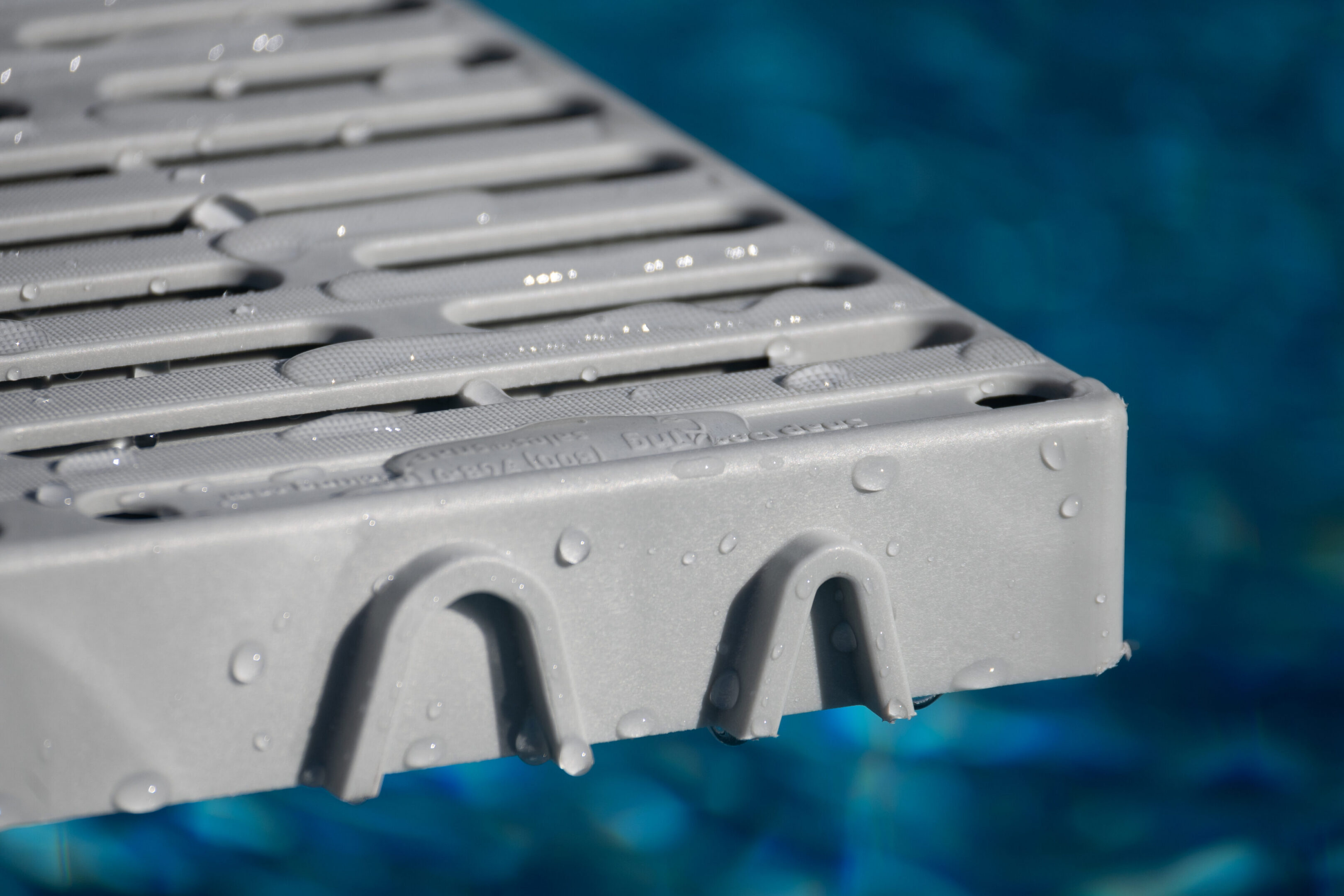 Gray pool deck with water droplets.