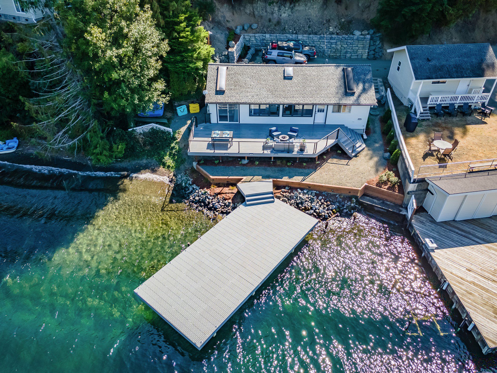 Lakeside house with dock and surrounding trees.