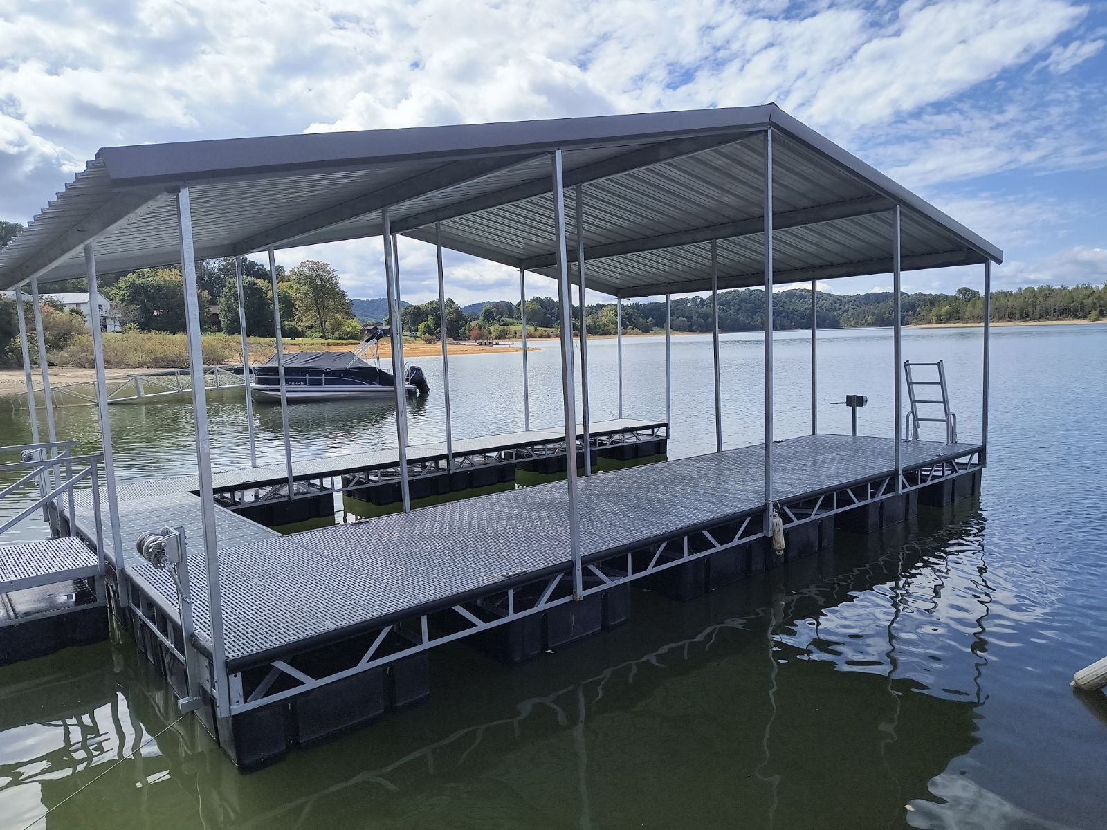 Floating dock with metal roof on lake.