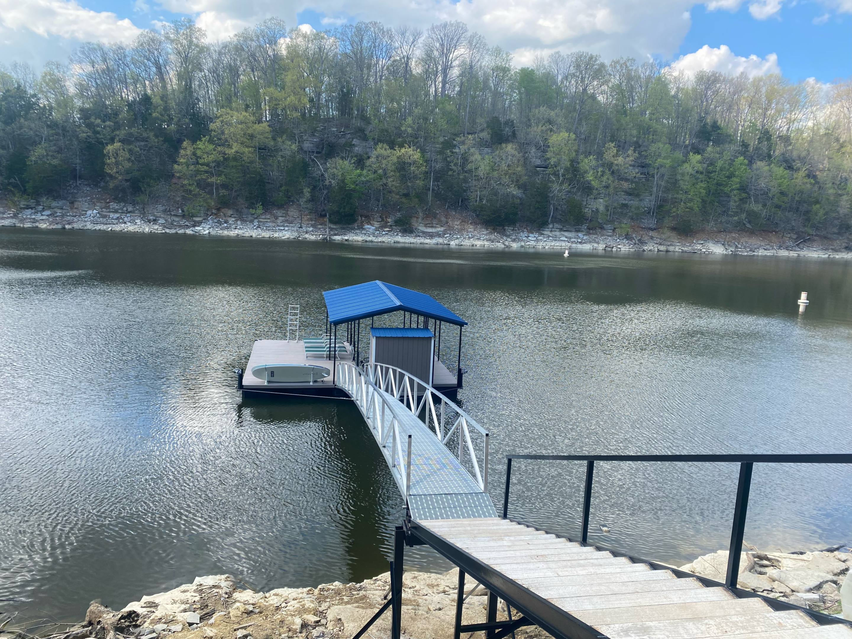 Dock with blue roof on calm lake.